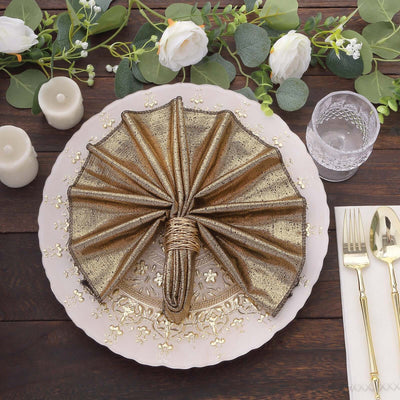 Elegant gold napkin folded in an umbrella shape on a decorative plate.