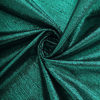 Shimmering teal sequin fabric with a textured surface.