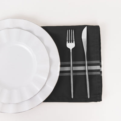 Plate, fork, and knife on a black napkin
