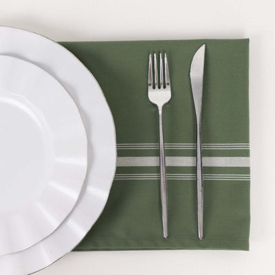 White dinner plate, fork, and knife on a green placemat.