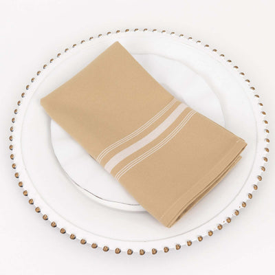 Beige napkin with white stripes on a decorative plate