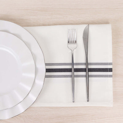Elegant table setting with white plate, fork, and knife on a stylish napkin.