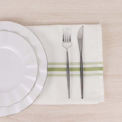 Elegant white dinner plate with silver trim, fork, knife, and green-striped napkin.