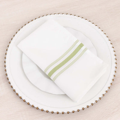 White napkin with green stripes on an elegant plate.