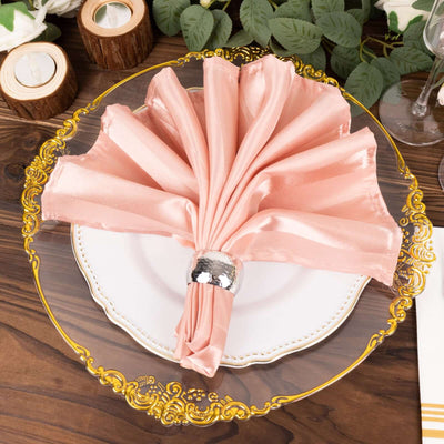 Elegant pink satin napkin with a silver ring on a decorative plate.