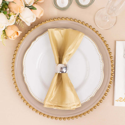 Elegant table setting with a gold napkin and decorative plate.