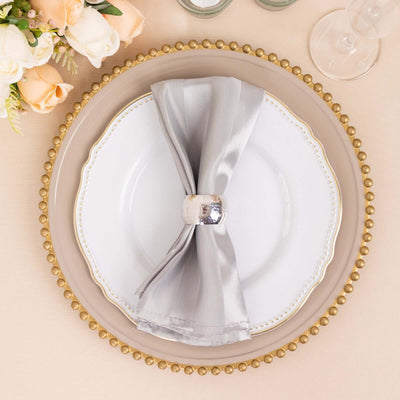 Elegant table setting with silver napkin and decorative plate.