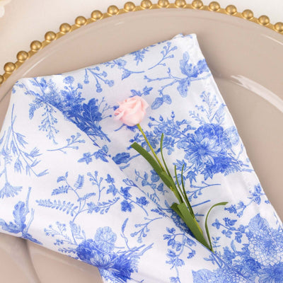 Blue floral napkin with pink flower on a decorative plate.
