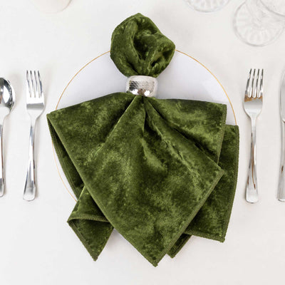 Green velvet folded napkin with silver napkin ring on elegant table setting