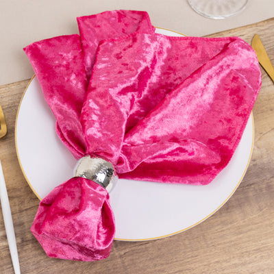 Pink velvet napkin elegantly tied on a plate with a silver napkin ring.