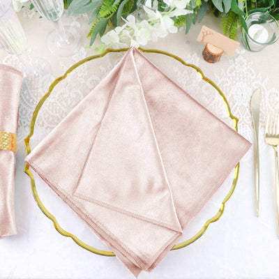 Rose gold satin napkin elegantly arranged on a decorative plate.