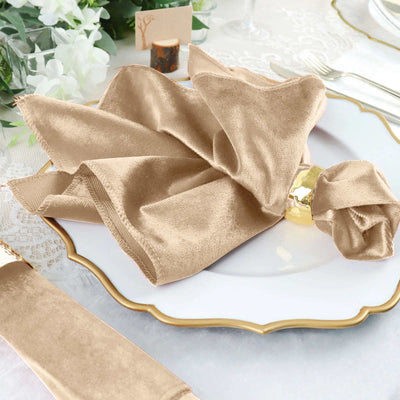 Elegant gold satin napkin on a decorative plate for dining.