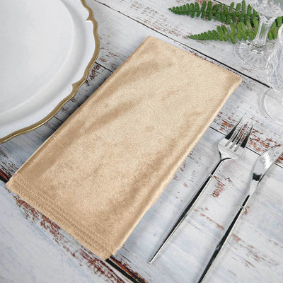 Elegant beige napkin on rustic table setting with fork and knife.