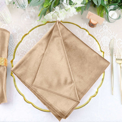 Elegant beige napkin on a decorative gold plate with floral accents.