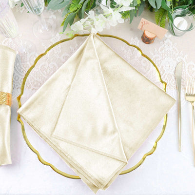 Gold satin napkin elegantly folded on a decorative gold plate.