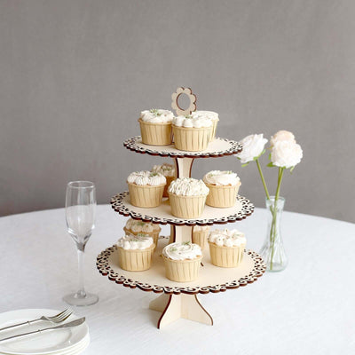 Wooden cupcake stand with decorated cupcakes, set on a table with flowers.