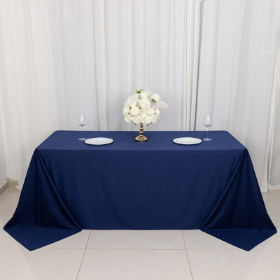 Navy blue tablecloth with white plates and floral centerpiece