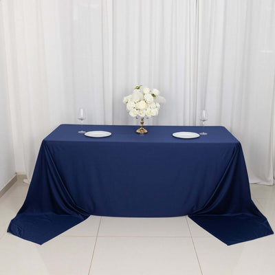 Navy blue tablecloth with white plates and floral centerpiece
