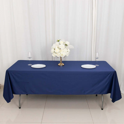 Navy blue tablecloth draped over a table with plates and floral centerpiece.