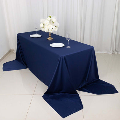 Navy tablecloth draped over a table set with plates and a floral centerpiece.