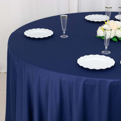 Navy tablecloth with white plates and floral centerpiece on a round table