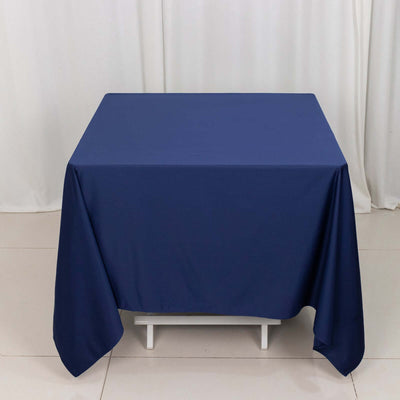 Navy blue tablecloth draped over a table against a neutral backdrop