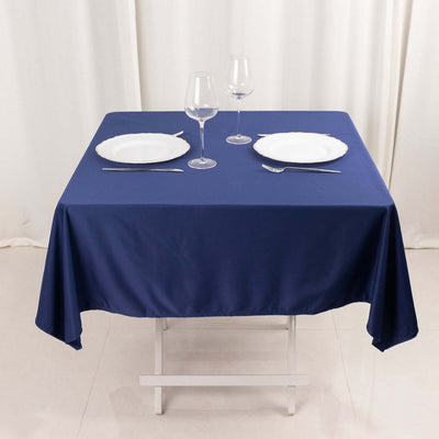 Navy tablecloth set with plates and glasses on a dining table