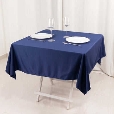 Navy tablecloth draped over a folding table with dining setup.