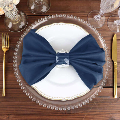 Navy blue satin napkin bow on an elegant dinner plate setting.