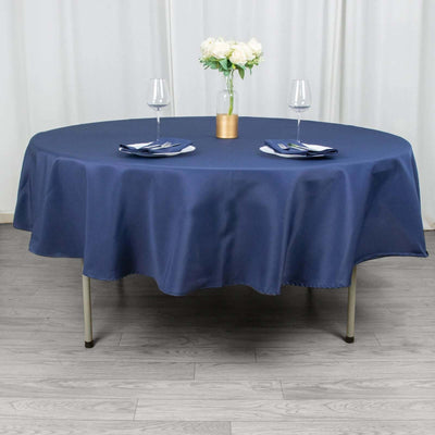 Navy round tablecloth with set dining table and floral centerpiece.