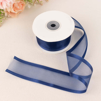 Navy blue sheer ribbon on a spool with a loose end.