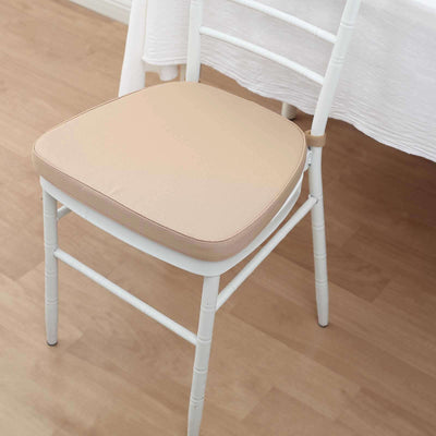 White chair with beige cushion on wooden floor.