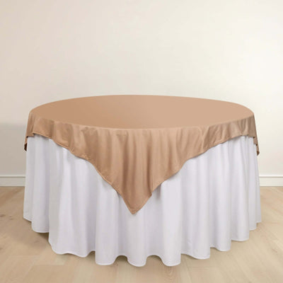 Round table with a beige satin tablecloth and white skirt.