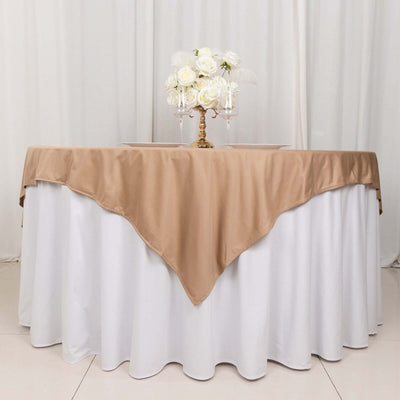 Table with beige satin tablecloth and floral centerpiece arrangement.
