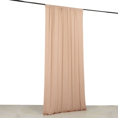 Peach fabric curtain draped on a rod against a plain background