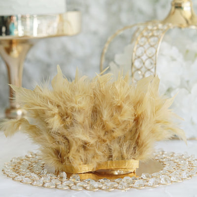 Gold feather centerpiece decoration on a sparkling table setting.