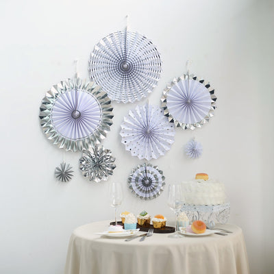 Decorative paper fans in silver and white for party decor.