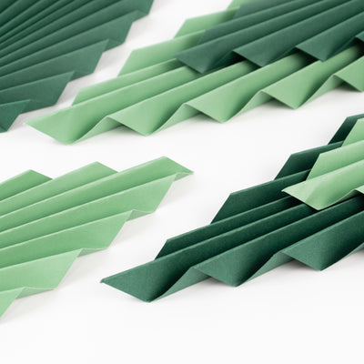 Green folded paper decorations in varying shades and textures