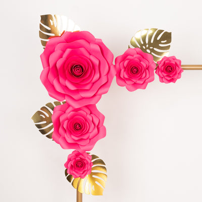 Pink paper flowers with gold leaves on a white background