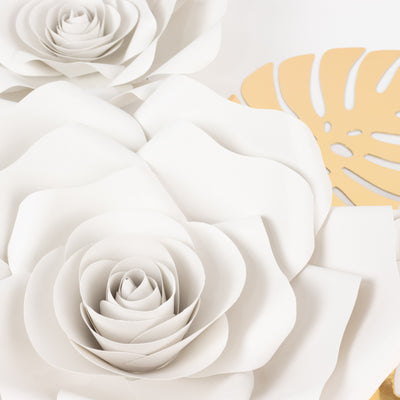 White paper flowers with intricate layers on a plain background.