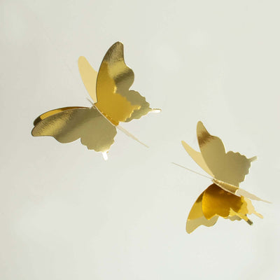 Gold butterfly decorations on a plain background