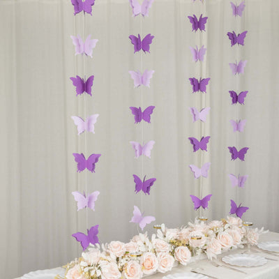 Purple butterfly decorations hanging above a table with pink roses.
