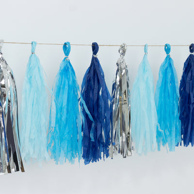 Blue and silver tissue paper tassels hanging on a string for decoration