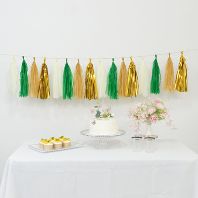 Colorful tassel garland above a cake and cupcakes on a festive table setting.