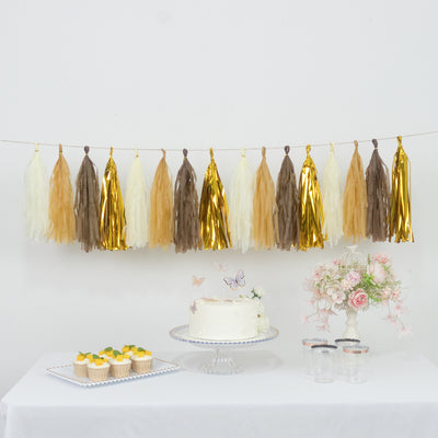 Decorative tassel garland in warm tones above a cake and dessert display.