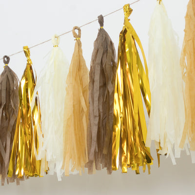 Decorative tassel garland in gold, brown, and cream shades on a string.
