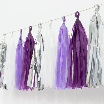 Purple and silver party tassels hanging on a string