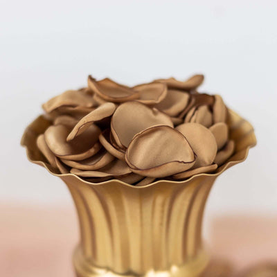 Golden vase filled with silk petals in neutral tones.