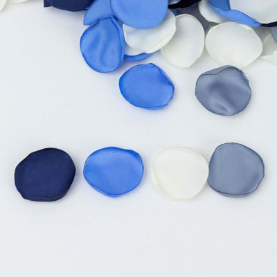 Assorted satin flower petals in blue, white, and gray on a white background.