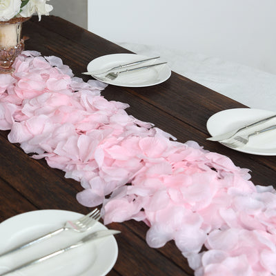 Pink and white flower petal table runner on a wooden dining table.